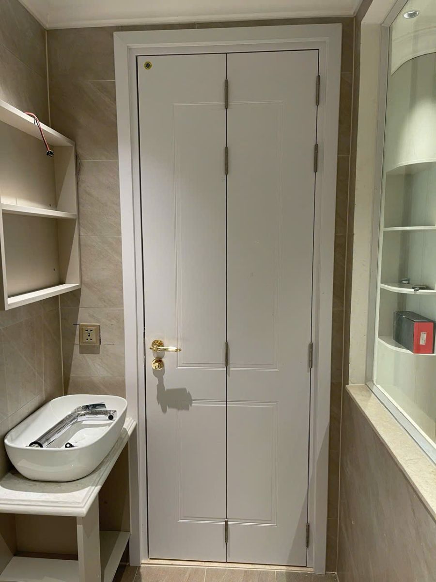 Mẫu cửa nhựa composite gập 2 cánh màu trắng lắp đặt cho nhà vệ sinh nhỏ, giúp tiết kiệm diện tích tối đa.