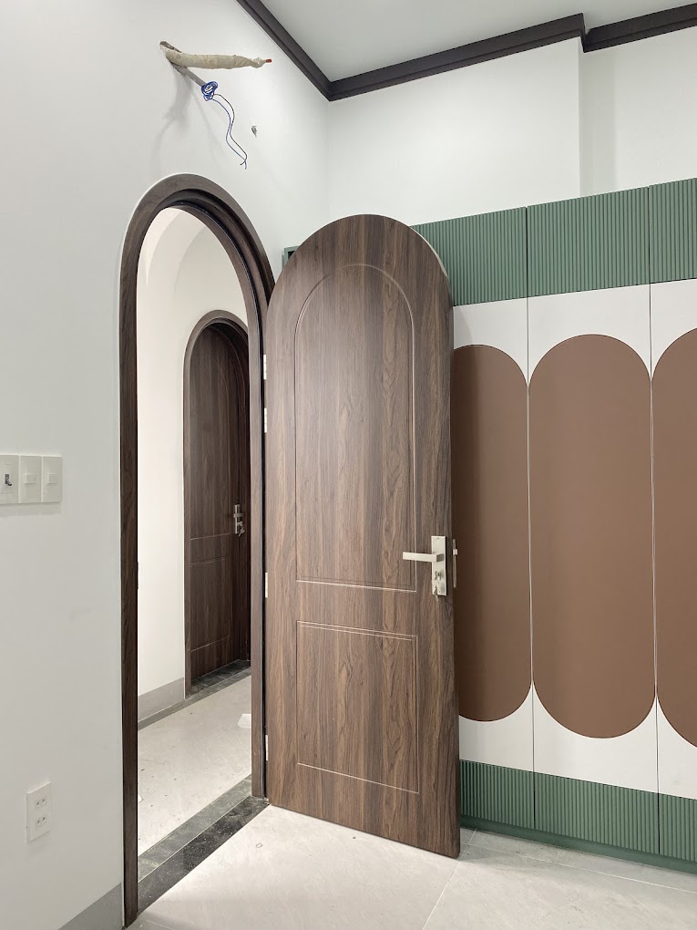 cửa vòm cong nhựa composite màu vân gỗ óc chó lắp cho phòng ngủ