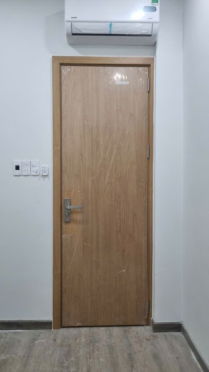 Hình ảnh thi công mẫu cửa WC nhựa Composite giả gỗ hoặc cửa Composite có ô kính mờ thẩm mỹ dành cho nhà vệ sinh tại Quận 1.