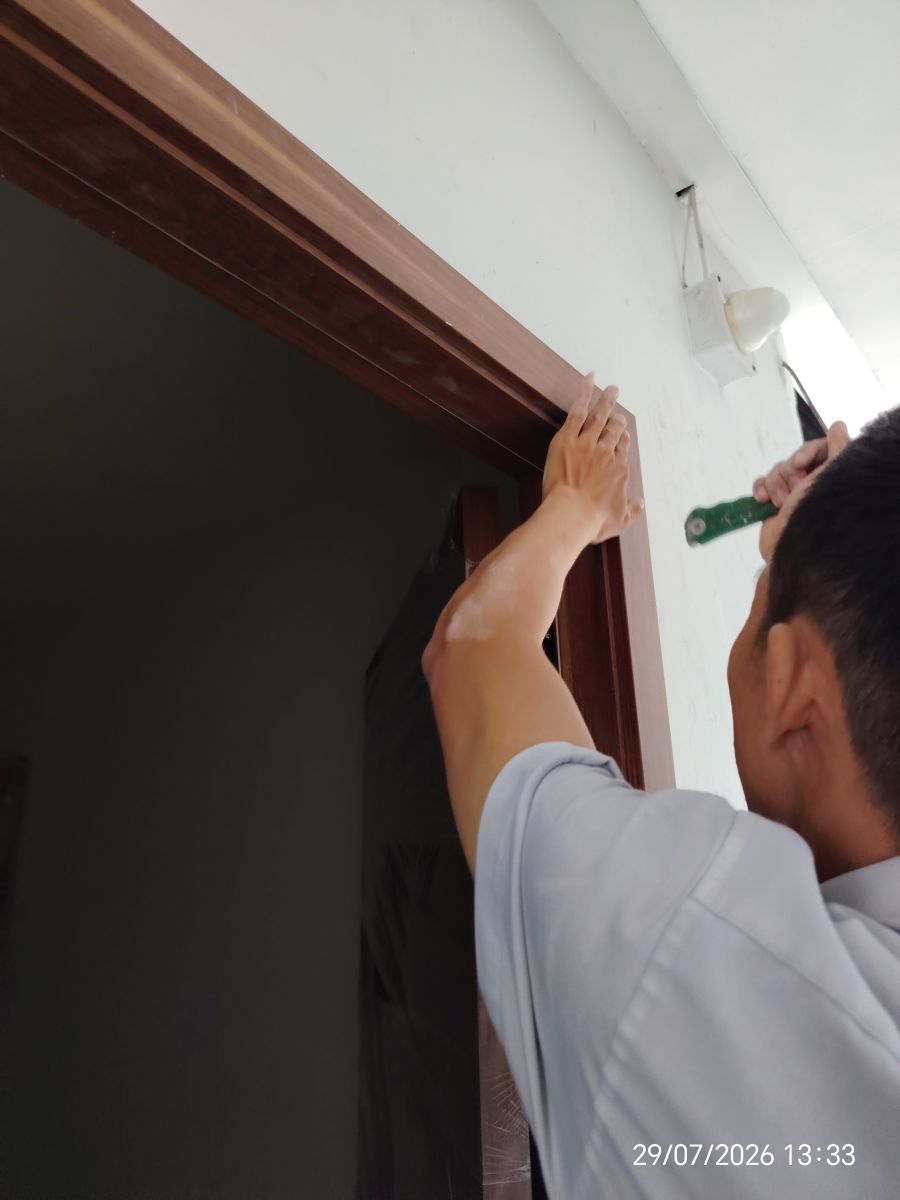 kĩ thuật đang tiến hành đóng nẹp khung cửa